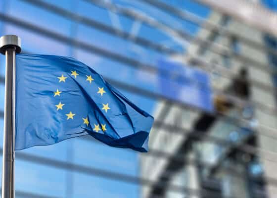European Union flags in front of the blurred European Parliament in Brussels, Belgium