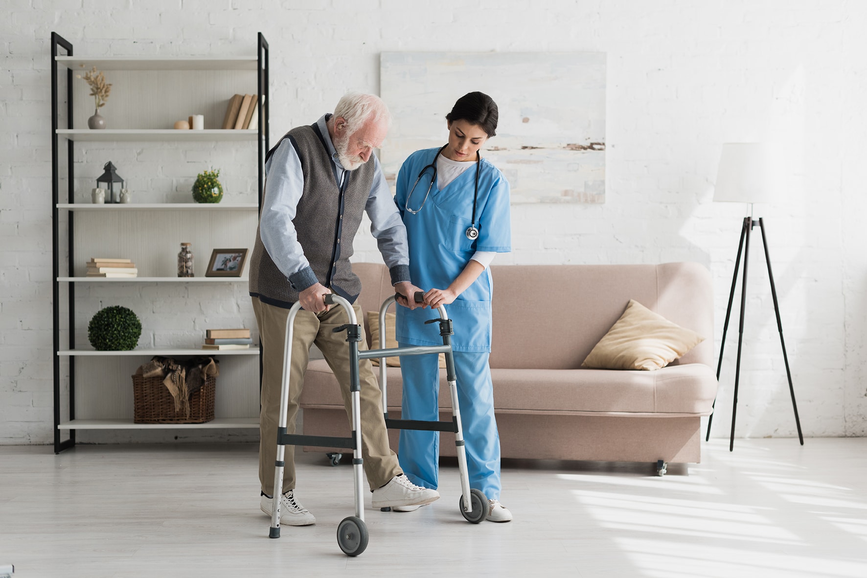 Nurse helping to senior man walking at home, recovering after injury