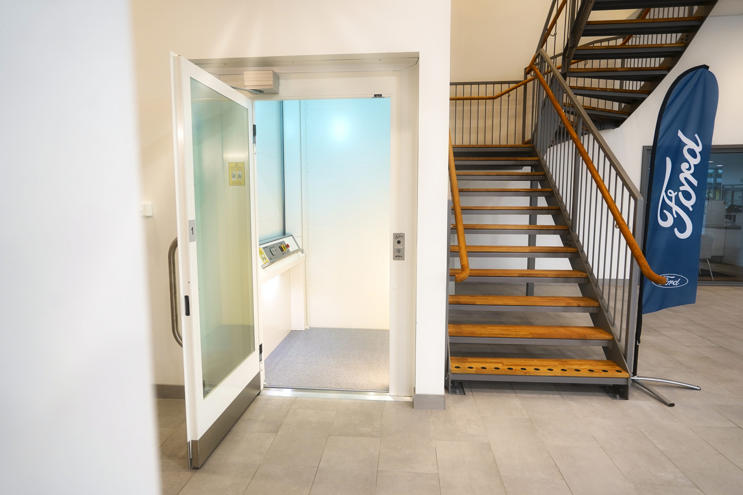 MC2000 Commercial Lift, viewed head-on next to a staircase.