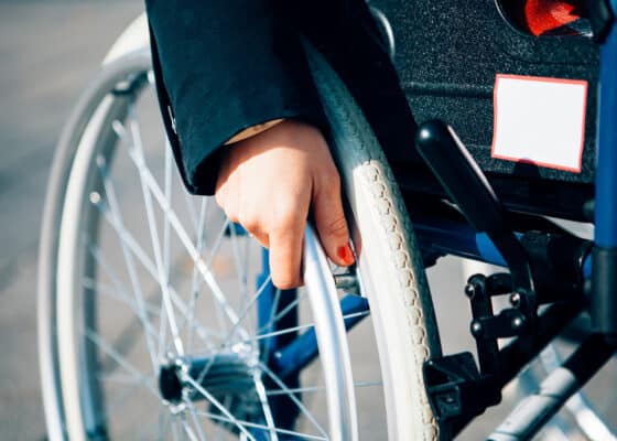 close up of a female hand holding a wheelchair - life with a disabilty concept